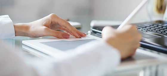 Person writing on a tablet